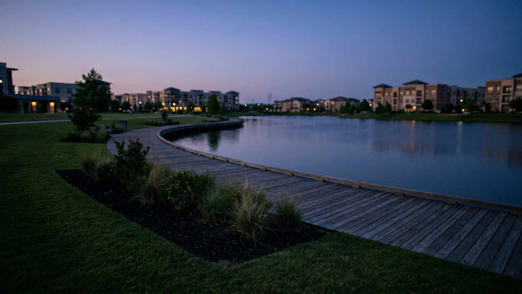 The Katy Boardwalk District lakefront and boardwalk at blue hour with downtown Katy beyond